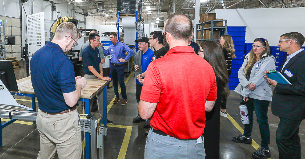 Hirsh employees show guests robotic automation used in manufacturing processes